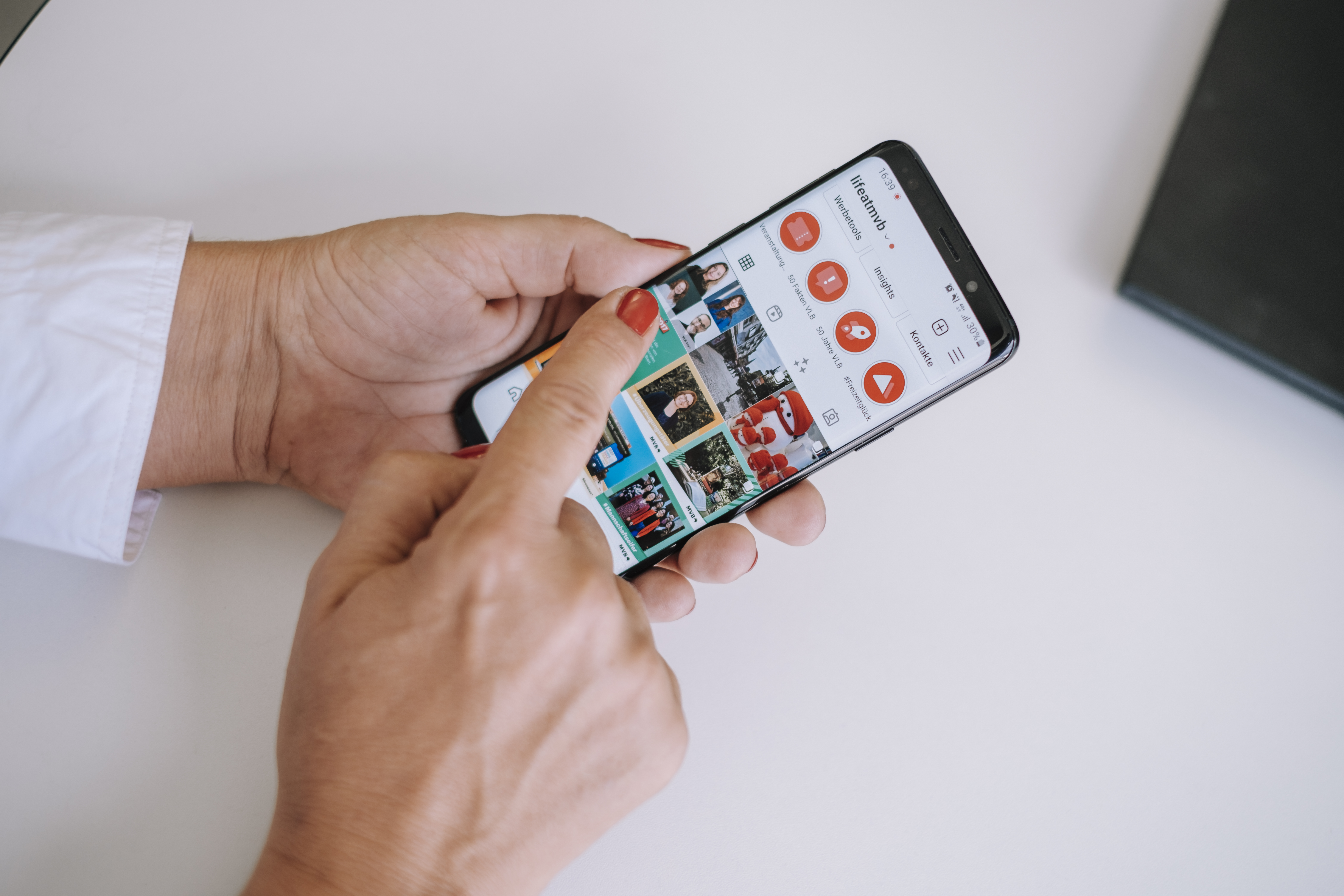 Eine Person hält ein Handy in der Hand und scrollt mit der anderen Hand durch Instagram.