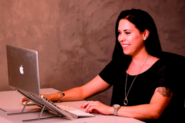 Priscila Xavier sitzt an einem Laptop