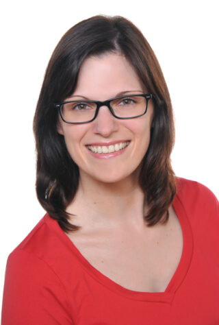 Autorin Jasmin Zipperling lächelnd vor einem weißen Hintergrund.