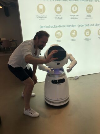 Der Roboter Cruzr interagiert mit einem Mann, der neben ihm steht.
