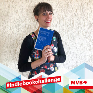 Rahel Trotta hält im Rahmen der Indiebookchallenge im Apirl das Buch "Warten auf Schnee" in den Händen und lächelt.