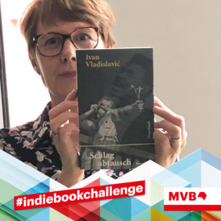 Sabinde van Endert hält im Rahmen der indiebookchallenge im August das Buch "Schlagabtausch" in den Händen und lächelt.
