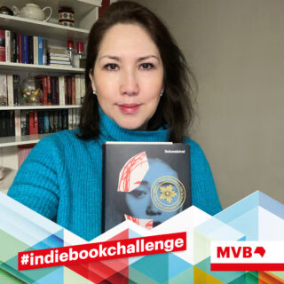 Bibi Setayesh hält in Rahmen der Indiebookchallenge das Buch "Die Insel der verlorenen Erinnerungen" in den Händen und lächelt.