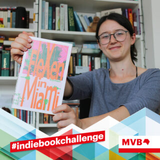Franziska Werum hält im Rahmen der Indiebookchallenge im Juni das Buch "Flexen in Miami" in den Händen und lächelt.