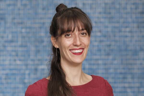 Portrait von Rahel vor einer blau gekachelten Wand