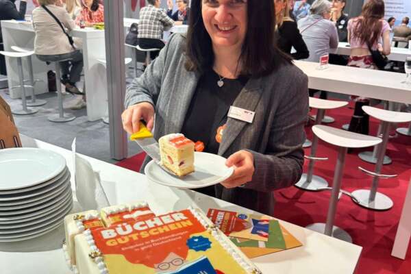 Karolin legt ein Stück der Büchergutschein-Torte auf einen Teller