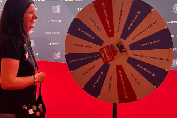 Karolin steht neben dem Büchergutschein-Glücksrad