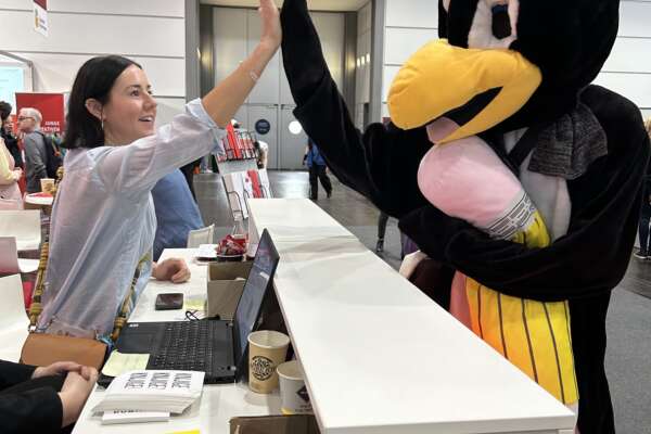 Ines klatscht sich mit einem Pinguin-Maskottchen ab