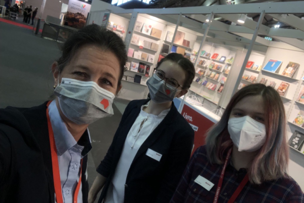 Selfie von Katharina Oppitz, Anna Göckel und einer weiteren Frau vor einem Messestand auf der Frankfurter Buchmesse.