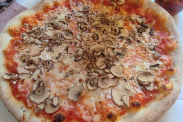 Pizza mit Tomatensoße, Käse und Champignons.