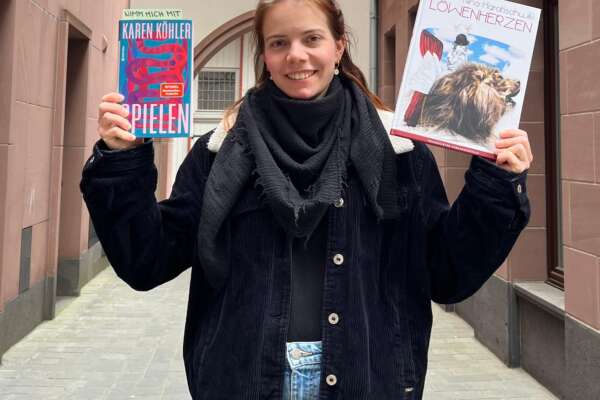 Jule hält zwei Bücher in der Hand, die sie in der Altstadt aussetzt.