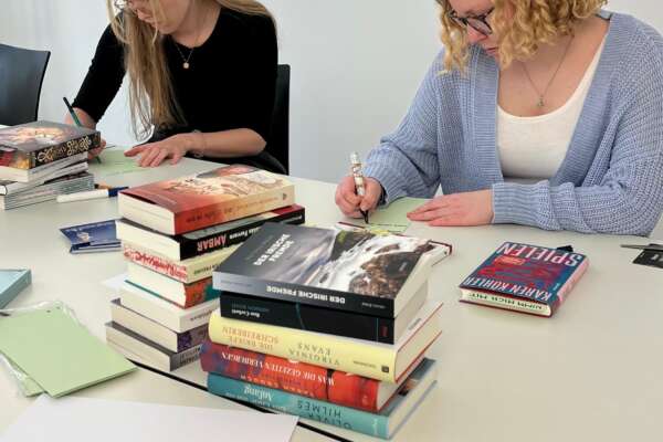Emely und Ronja widmen Bücher für den Welttag des Buches.
