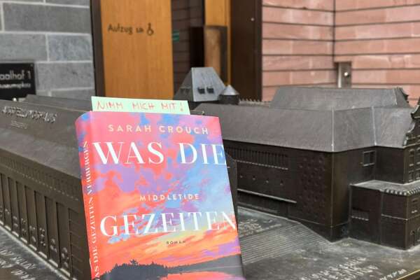 Ein zum Welttag des Buches verstecktes Buch an einem Bronze-Relief