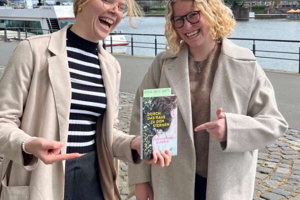 Emely und Ronja verstecken Bücher am Mainufer