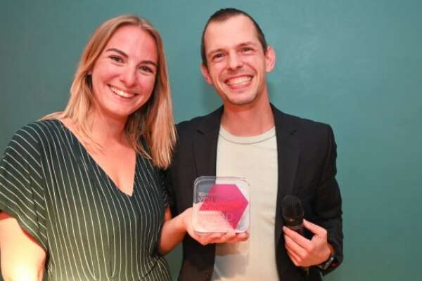 Die Gewinnerin des Young Excellence Award, Valerie Hentschel, hält ihren Award in der Hand und lächelt.