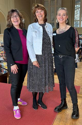 Stephanie Lange lacht mit zwei Mitarbeiterinnen der Buchhandlung Ludwig in die Kamera