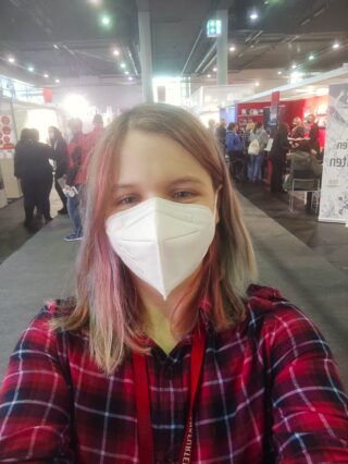 Anna Goeckel nimmt ein Selfie auf der Leipziger Buchmesse auf und trägt dabei eine FFP2-Maske.