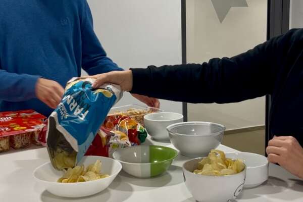 Christian Triebstein und Kirsten Blessing befüllen Schüsseln mit Chips