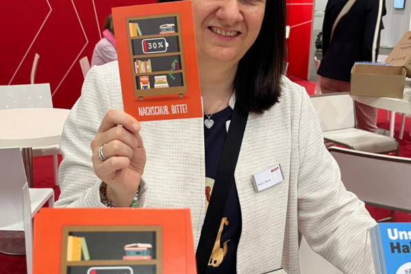 Karolin hält eine Büchergutschein-Postkarte in der Hand