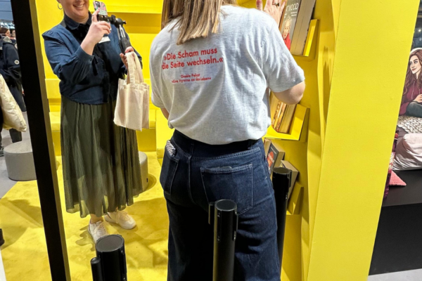 Katrin fotografiert eine Person am Piper Stand, wie sie eine Flaschenpost aufstellt.